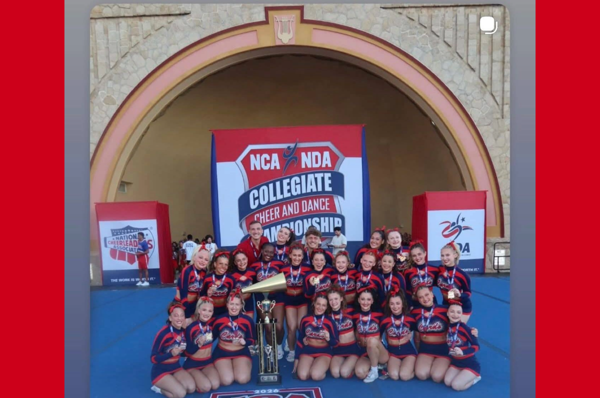 group of cheerleaders in front of banner